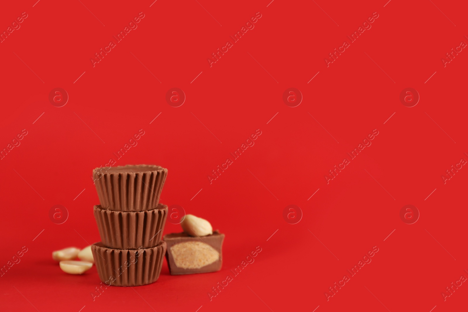 Photo of Sweet peanut butter cups on red background. Space for text