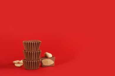 Photo of Sweet peanut butter cups on red background. Space for text