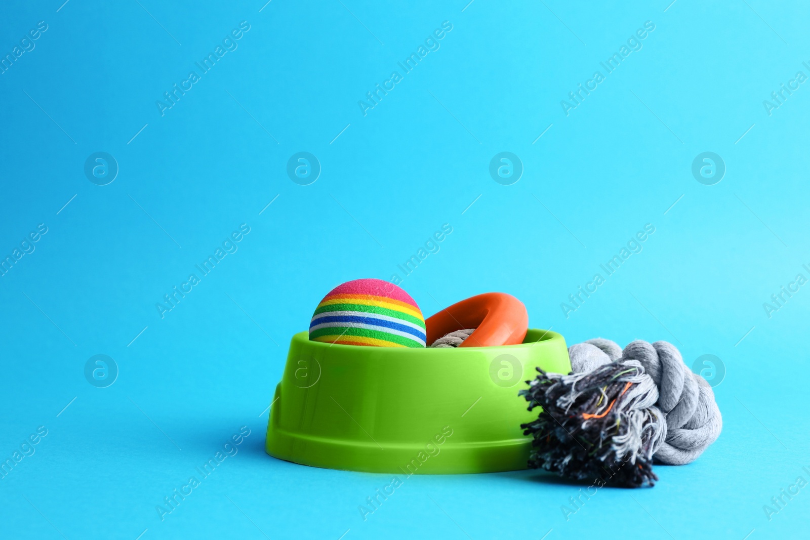 Photo of Pet toys and feeding bowl on light blue background