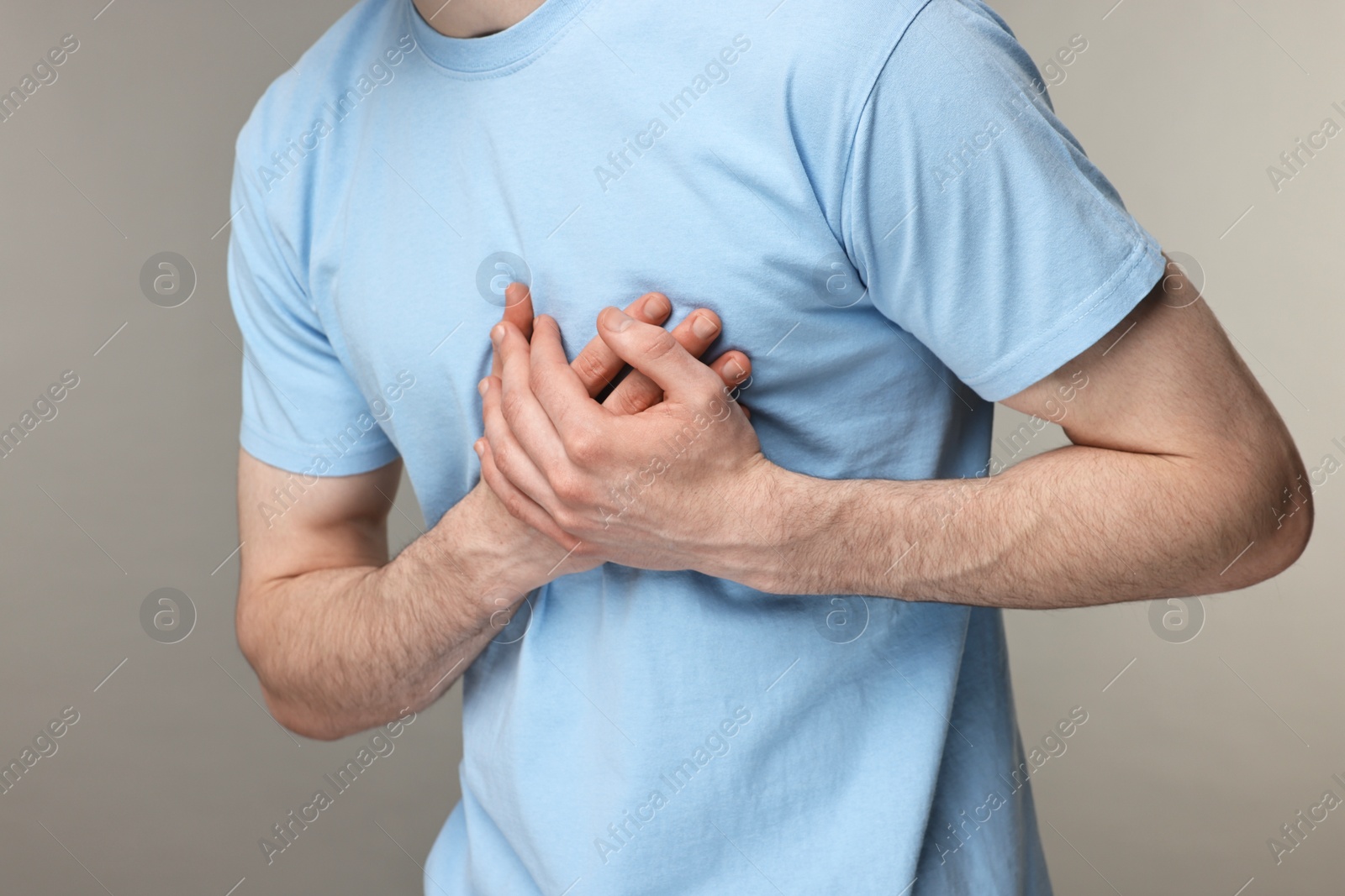 Photo of Man suffering from heart hurt on grey background, closeup