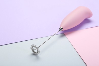 Photo of Pink milk frother wand on color background