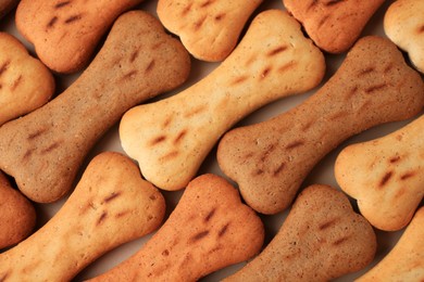 Photo of Bone shaped dog cookies as background, top view