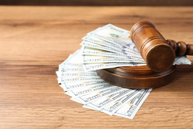 Photo of Judge's gavel and money on wooden table. Space for text