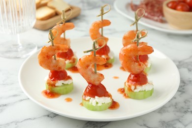 Photo of Tasty canapes with shrimps, vegetables and cream cheese on white marble table