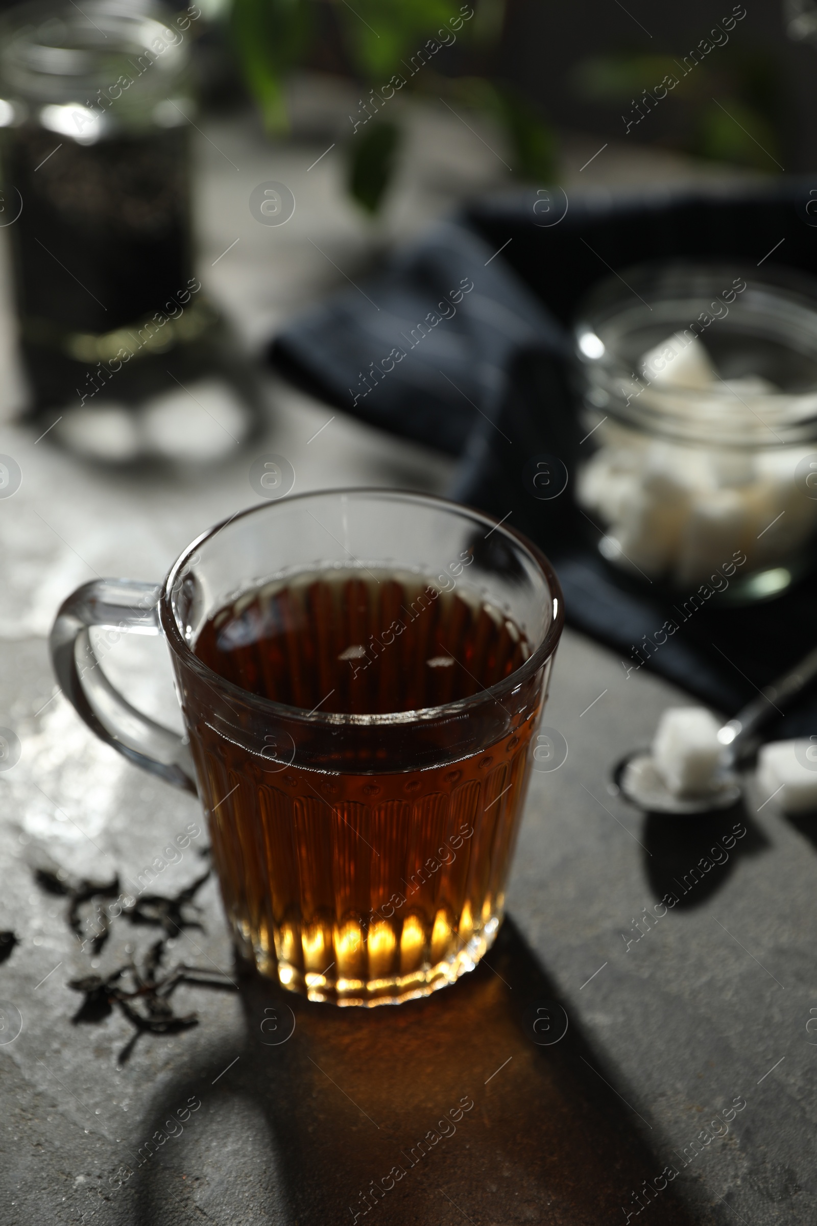 Photo of Tasty hot tea in cup on grey table, closeup