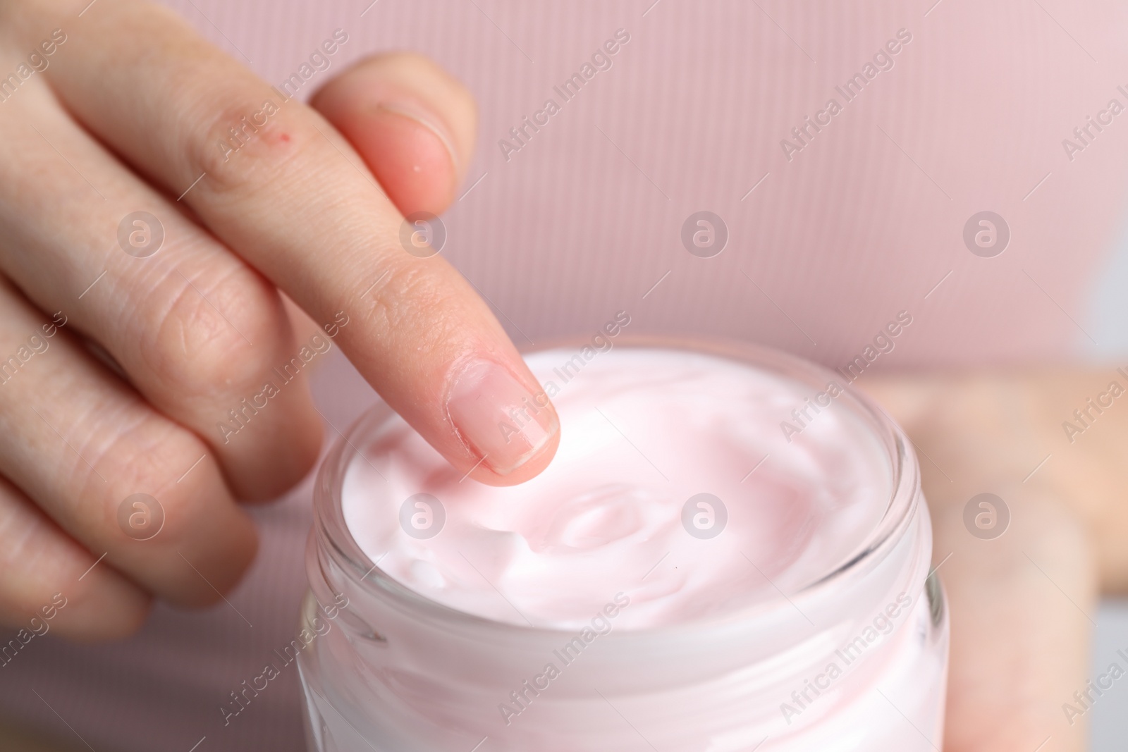 Photo of Woman holding jar of hand cream, closeup. Space for text