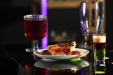 Bright delicious shot in glass and pizza on table