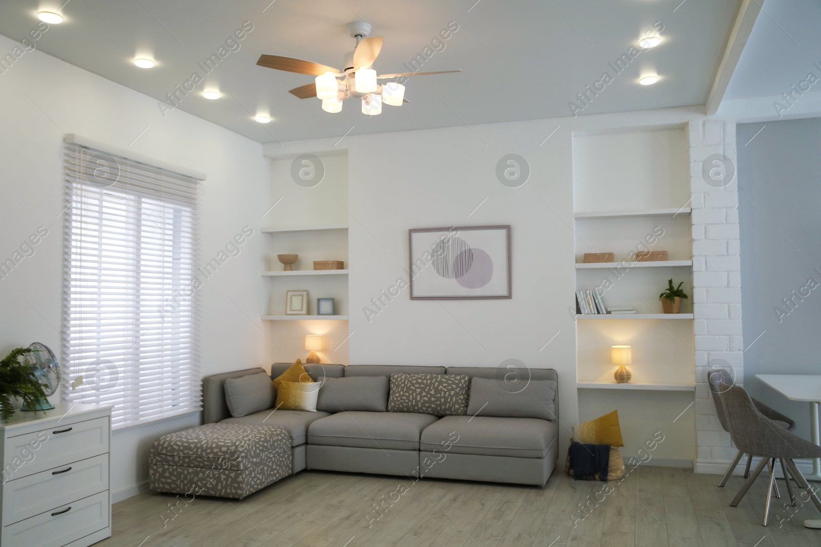 Photo of Comfortable furniture, ceiling fan and accessories in stylish living room