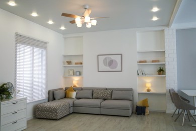 Comfortable furniture, ceiling fan and accessories in stylish living room