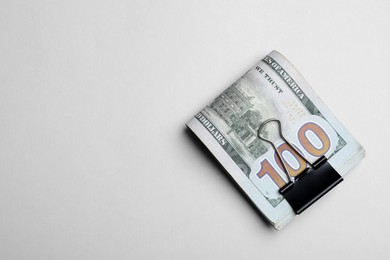 Photo of Dollar banknotes with paper clip on white background, top view