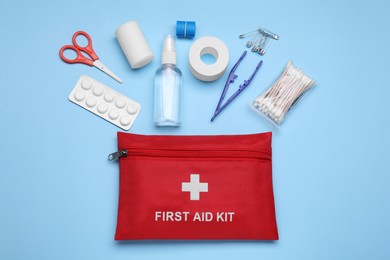 Photo of Flat lay composition with first aid kit on light blue background