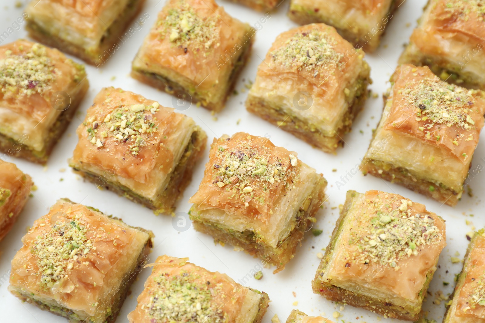 Photo of Delicious fresh baklava with chopped nuts on white table, closeup. Eastern sweets