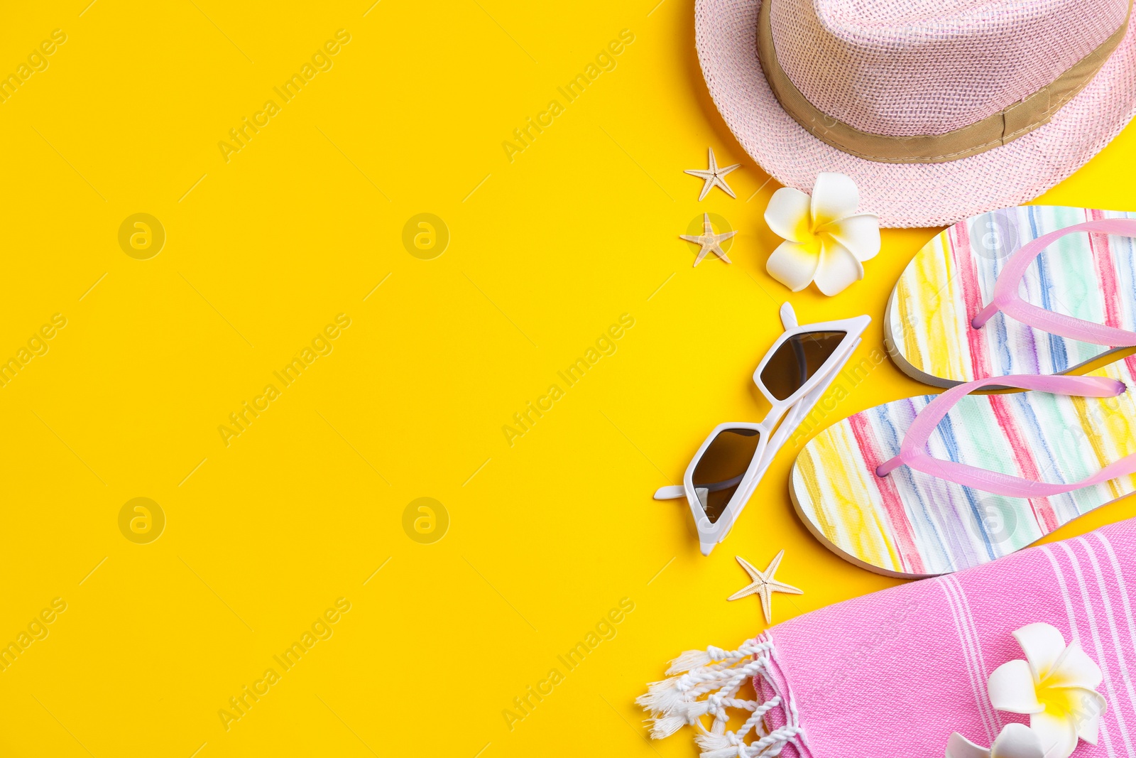 Photo of Flat lay composition with sunglasses and beach accessories on yellow background. Space for text