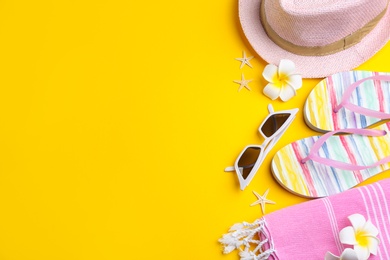 Photo of Flat lay composition with sunglasses and beach accessories on yellow background. Space for text