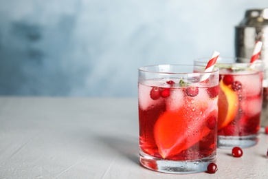 Photo of Tasty refreshing cranberry cocktail on grey table. Space for text