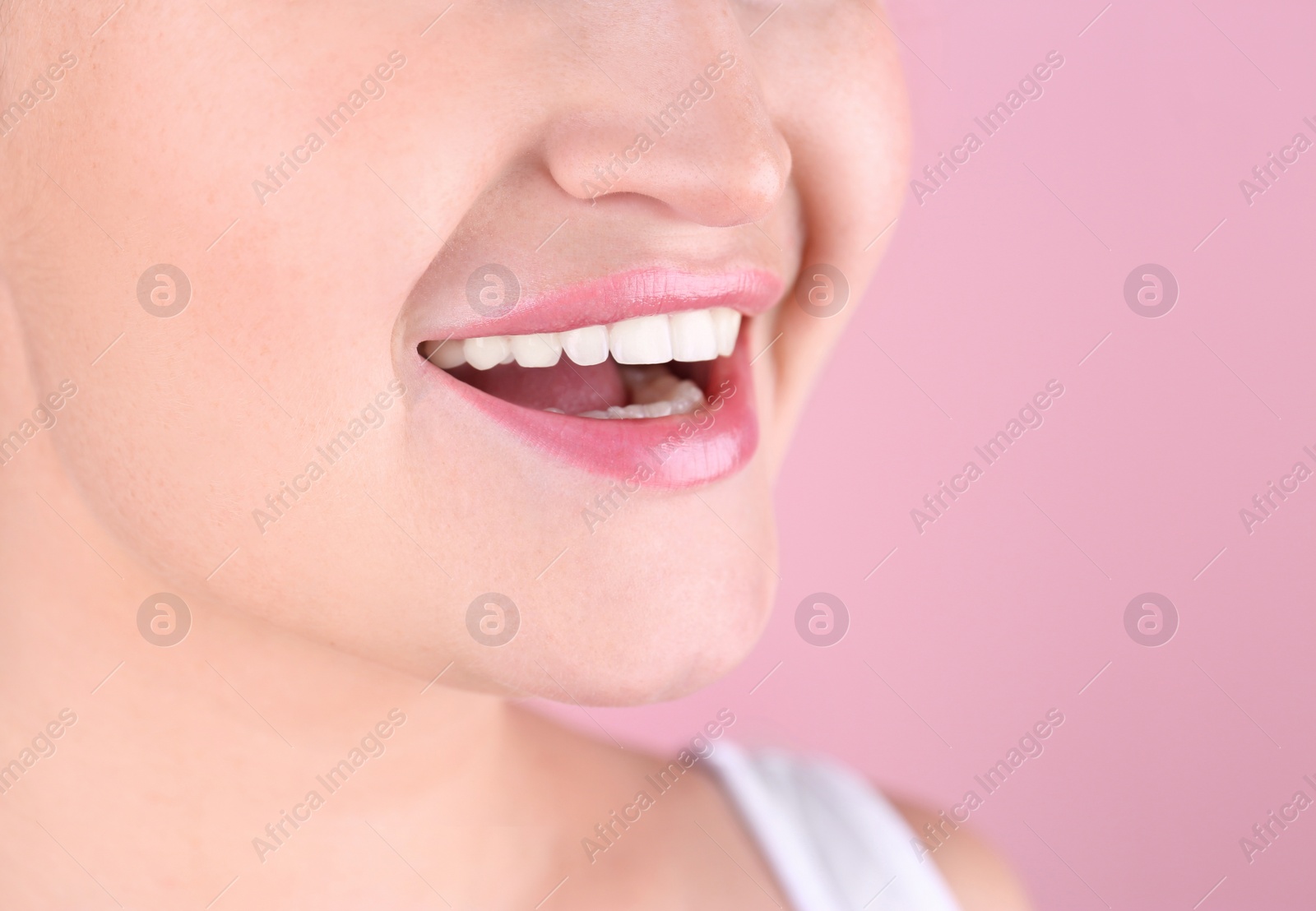 Photo of Young woman with beautiful smile on color background, closeup. Space for text