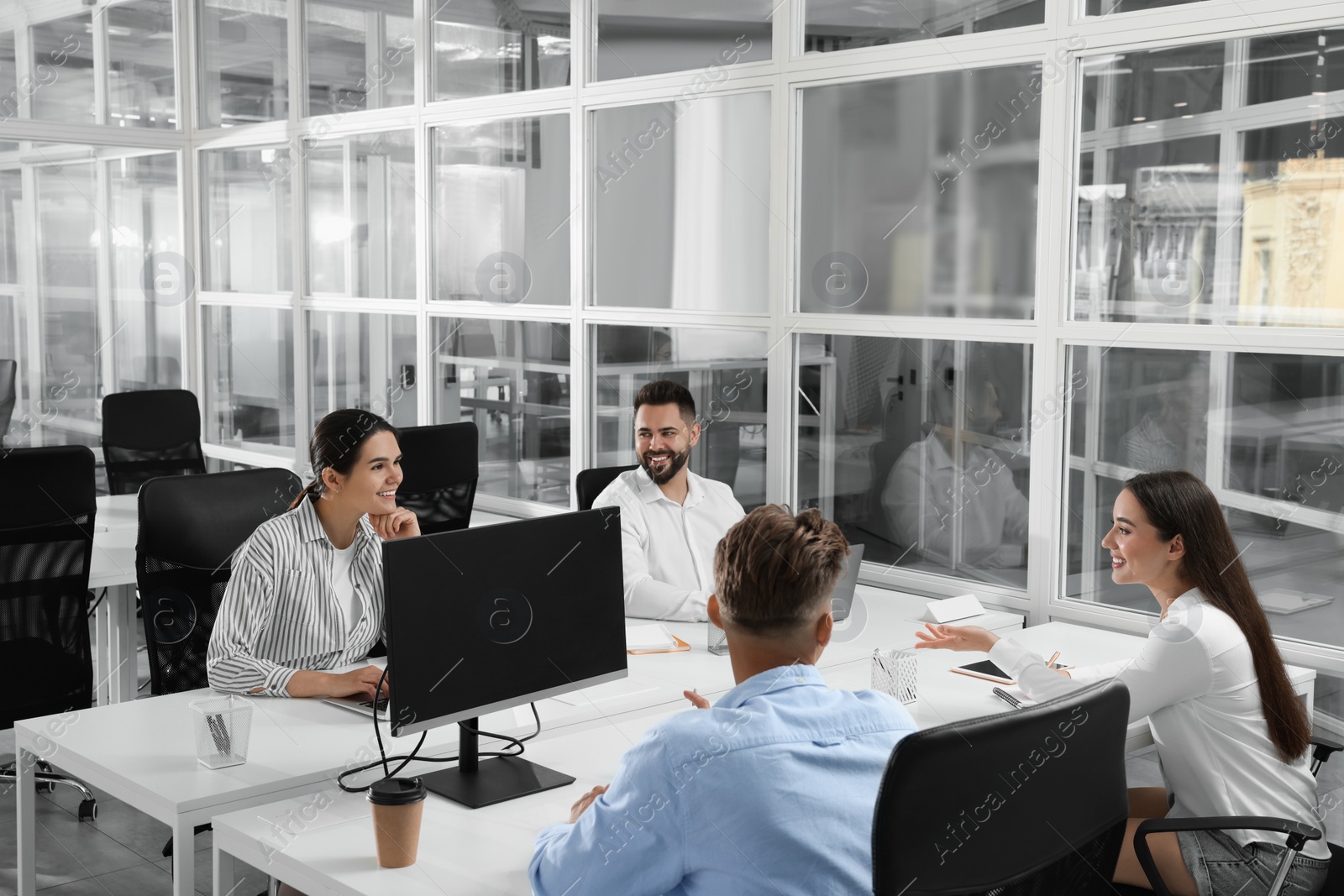 Photo of Colleagues working together in open plan office