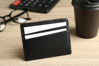 Photo of Leather business card holder with cards on wooden table