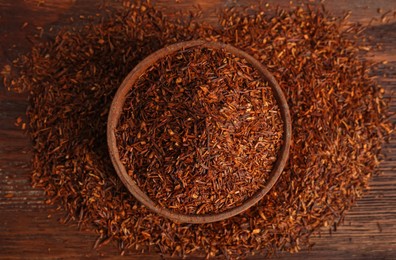 Dry rooibos leaves on wooden table, flat lay