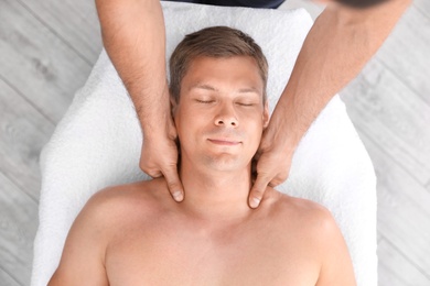 Photo of Relaxed man receiving head massage in wellness center, top view