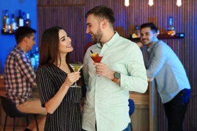 Photo of Young couple with martini cocktails at party