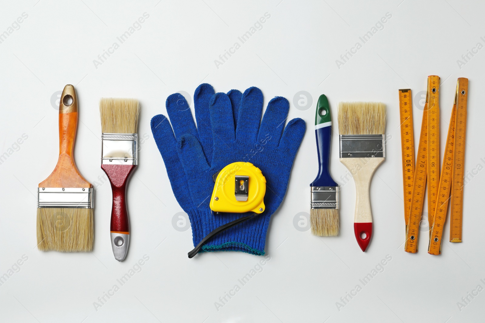 Photo of Set of decorator's tools on light background, flat lay