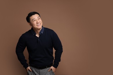 Photo of Portrait of happy man on brown background. Space for text