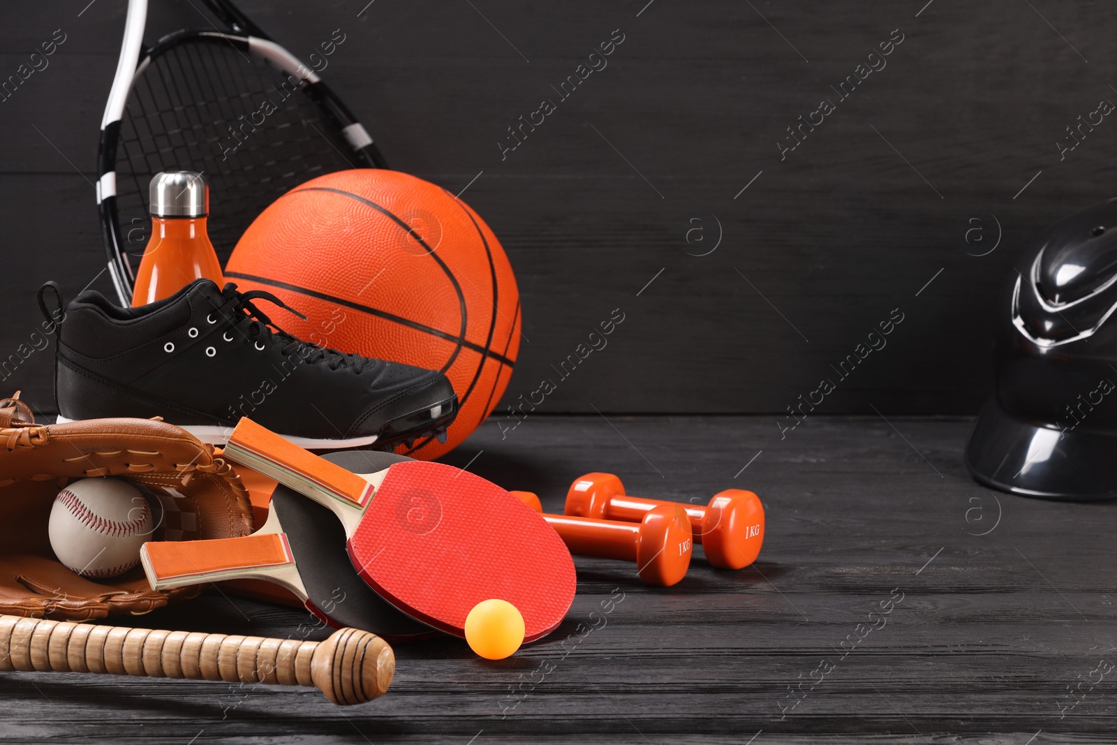 Photo of Many different sports equipment on dark grey wooden table