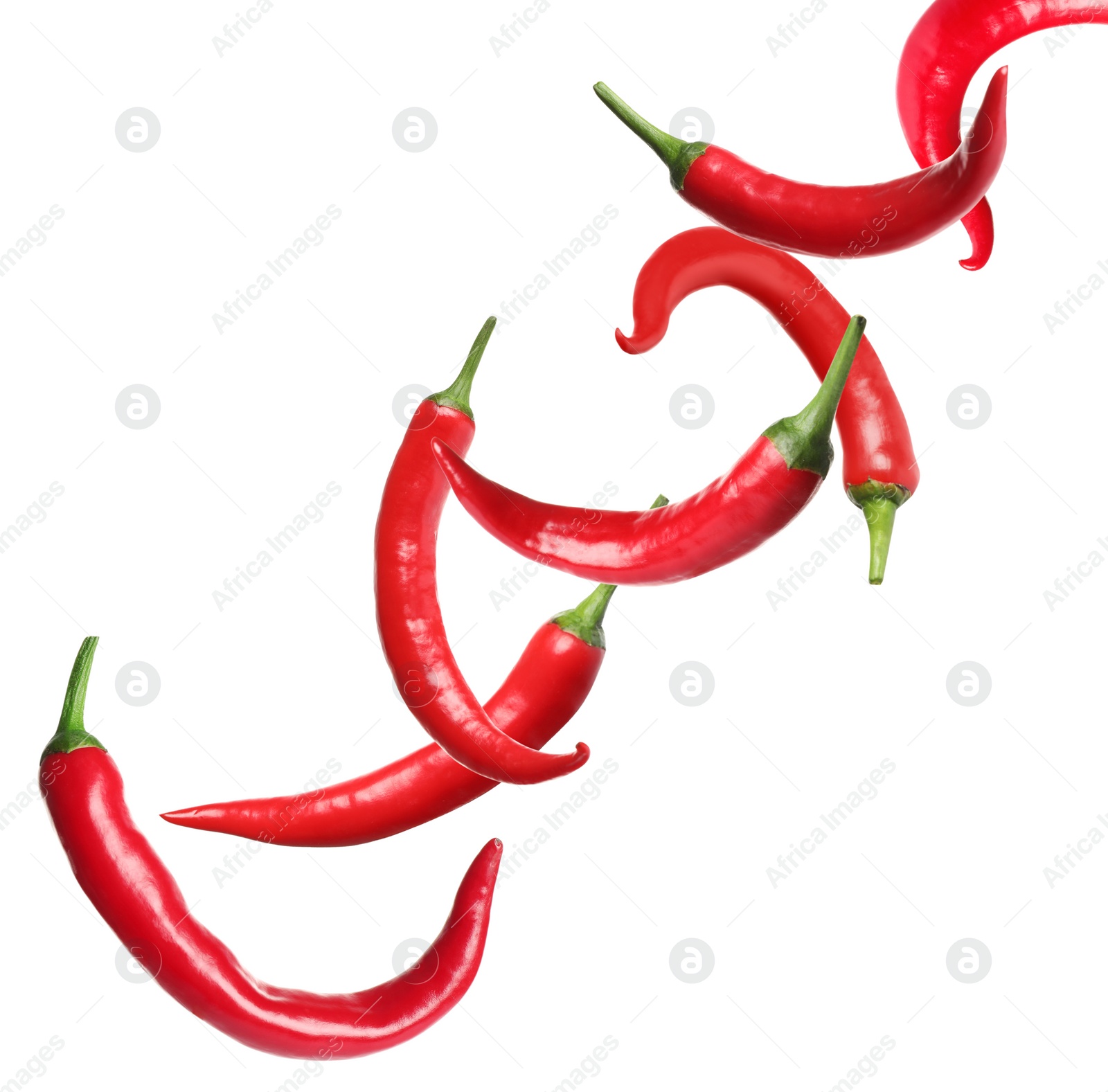 Image of Ripe red chili peppers flying on white background
