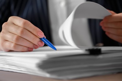 Photo of Woman signing documents at table in office, closeup