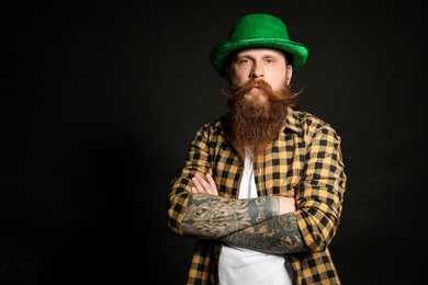 Photo of Bearded man in green hat on black background, space for text. St. Patrick's Day celebration