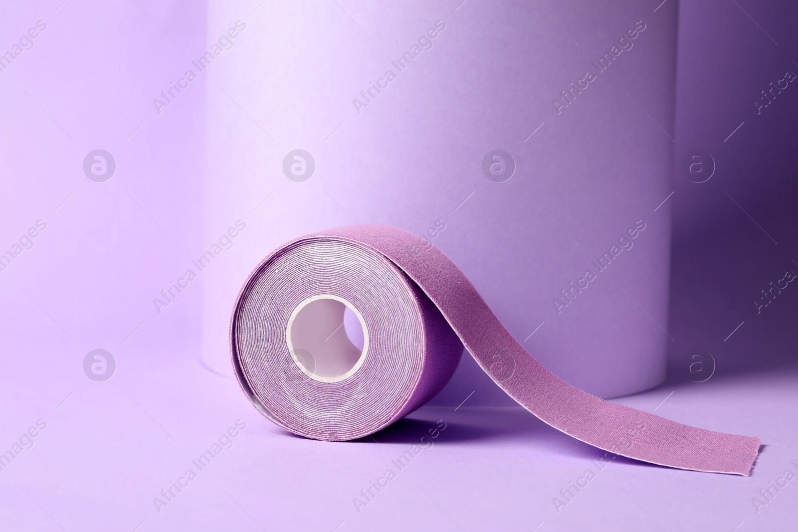 Photo of Bright kinesio tape in roll on lilac background