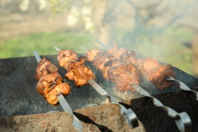 Photo of Cooking delicious meat on brazier outdoors, closeup