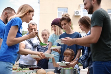 Photo of Volunteers serving food for poor people outdoors