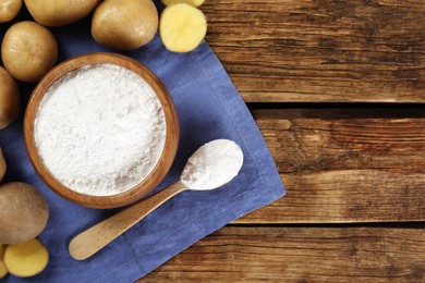 Starch and fresh raw potatoes on wooden table, flat lay. Space for text