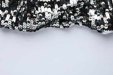 Photo of Beautiful shiny sequin fabric on white background. Space for text