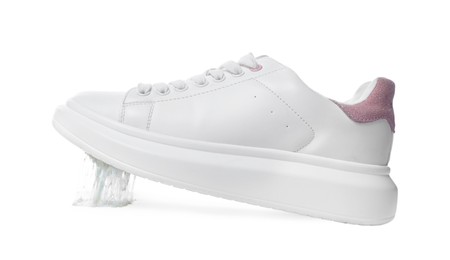 Shoe with chewing gum on sole against white background