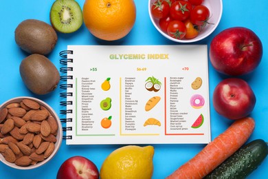 Glycemic index. Information about grouping of products under their GI in notebook, almonds, fruits and vegetables on light blue background, flat lay