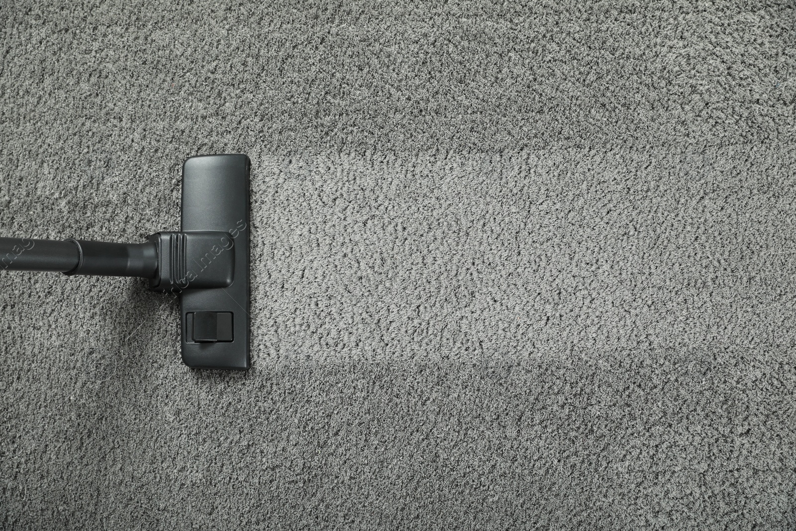 Photo of Vacuuming grey carpet. Clean area after using device, top view. Space for text