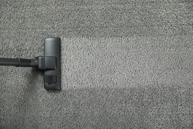 Vacuuming grey carpet. Clean area after using device, top view. Space for text