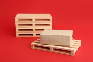 Photo of Wooden pallets and box on red background