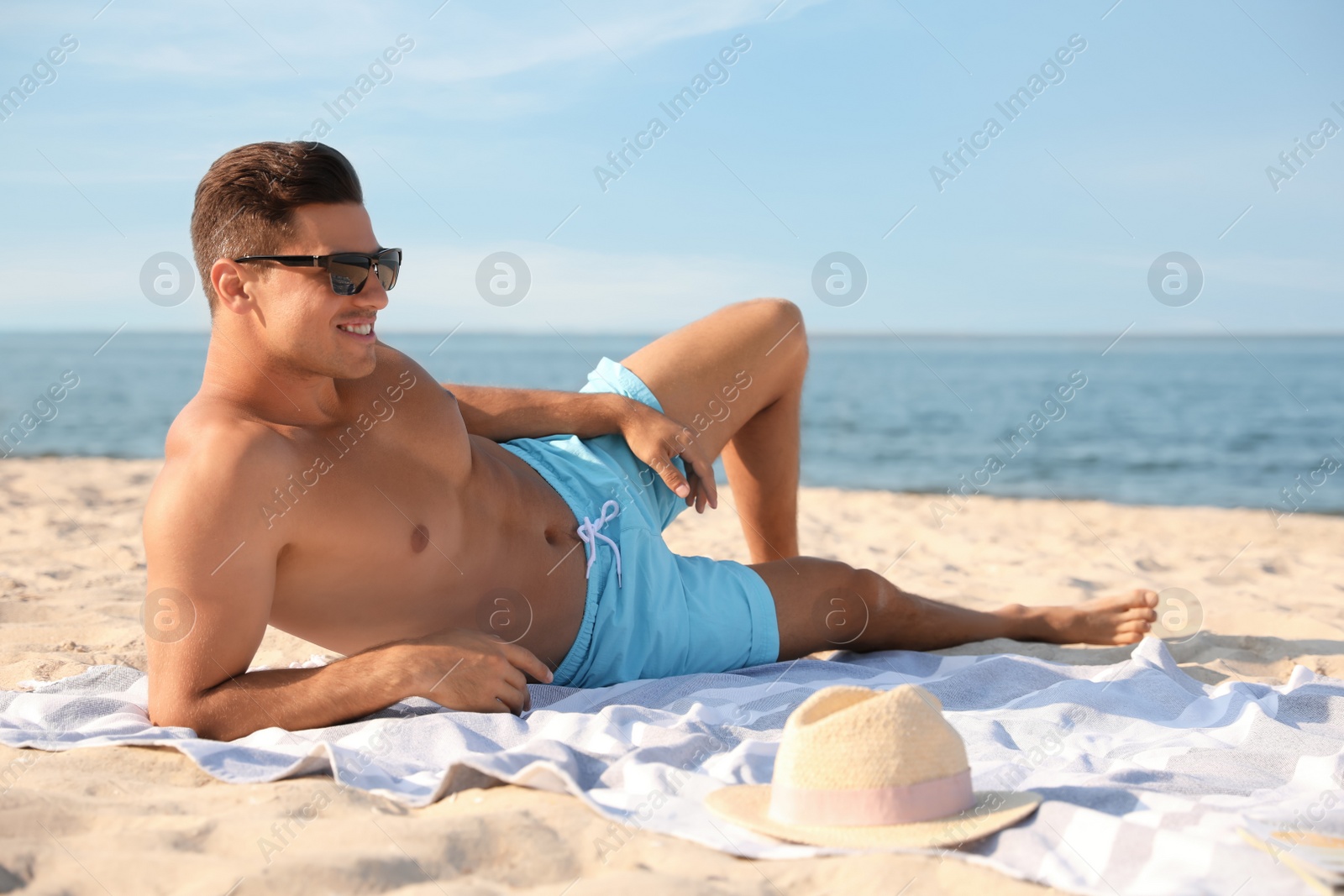 Photo of Happy man with slim body resting on beach