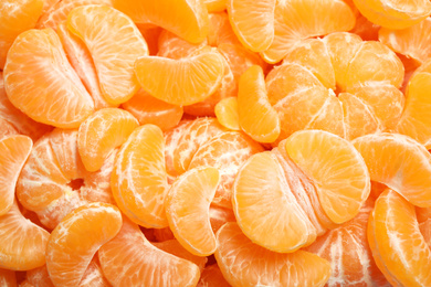 Photo of Fresh juicy tangerine segments as background, top view