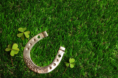 Flat lay composition with horseshoe on grass, space for text. St. Patrick's Day celebration