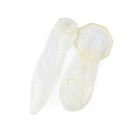 Photo of Unrolled female and male condoms isolated on white, top view. Safe sex