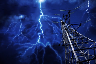 Picturesque lightning storm over high voltage tower, low angle view