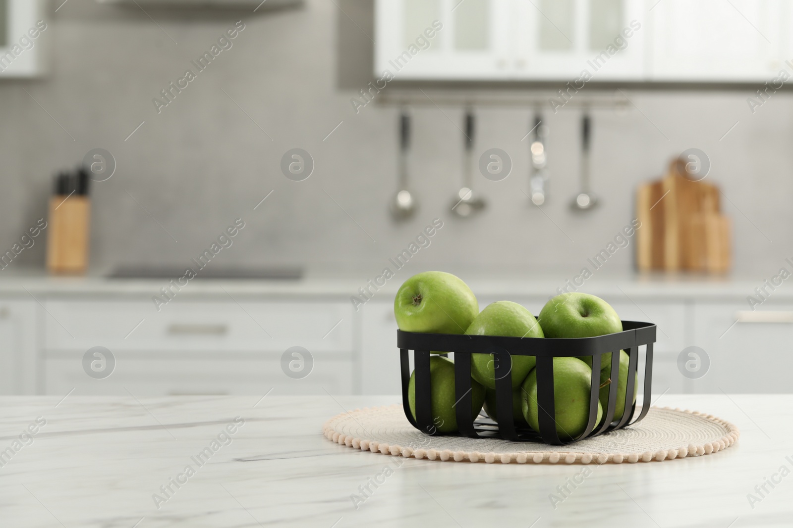 Photo of Fresh green apples on white table in kitchen, space for text