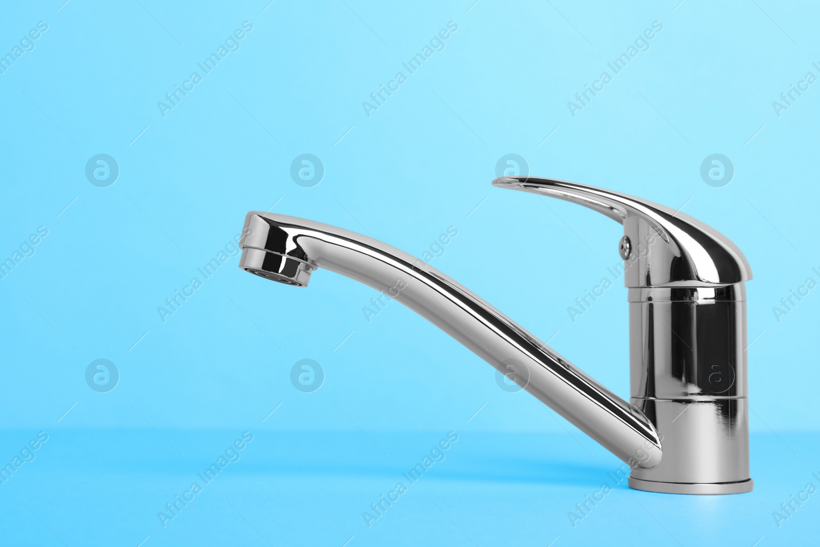 Photo of Single handle water tap on light blue background