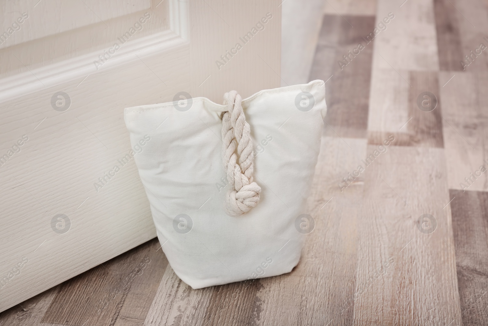 Stuffed bag holding wooden door at home Photo of Stuffed bag holding wooden door at home