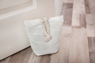Photo of Stuffed bag holding wooden door at home